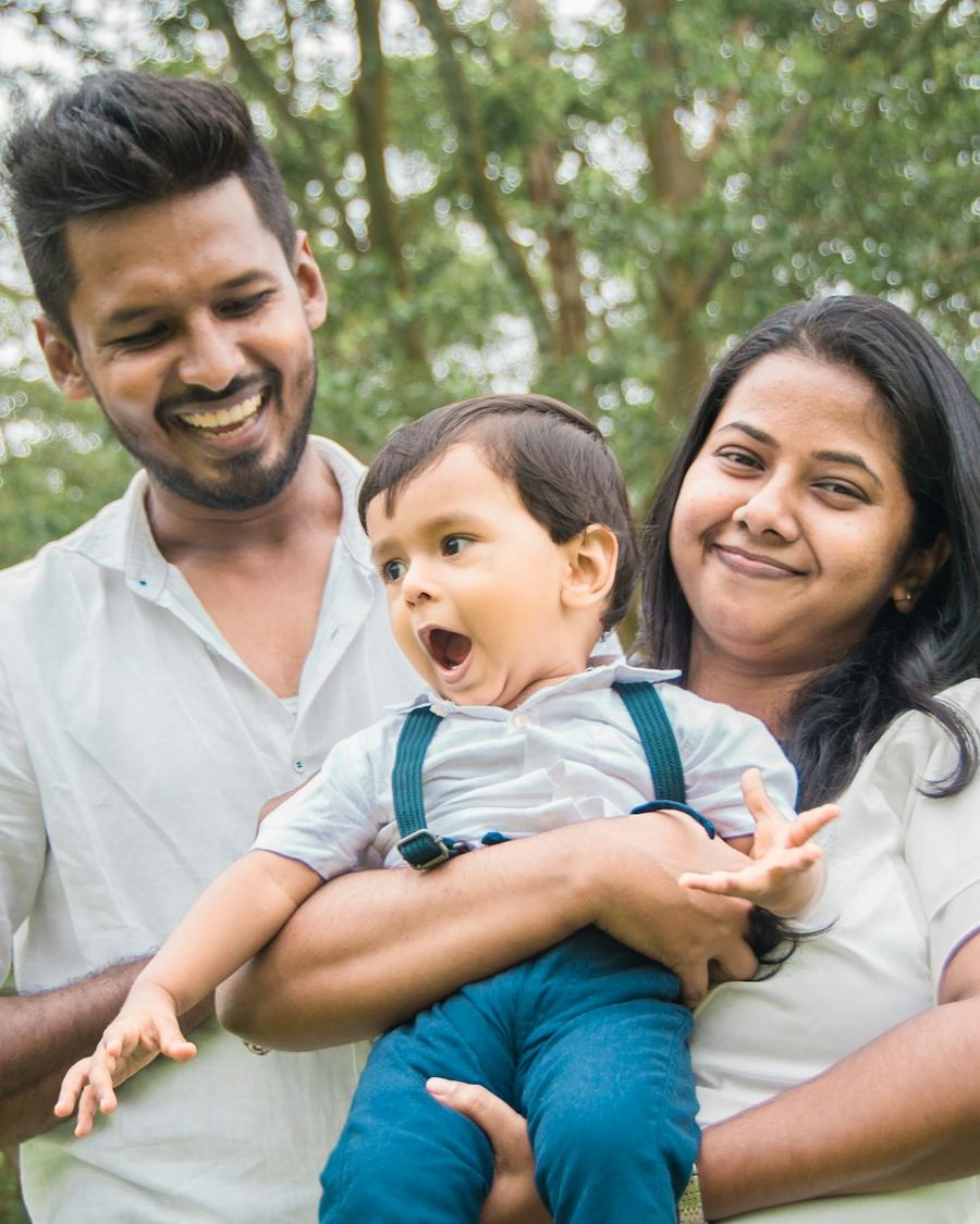 The Desai family with their baby outdoors, smiling